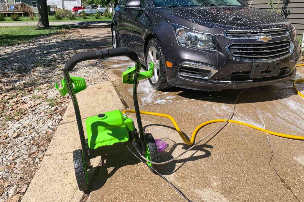 Beginner using a pressure washer on a car at a car wash in Lagos Nigeria