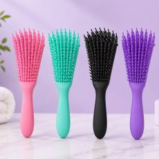 Professional detangling brushes in pink, purple, and turquoise for curly and textured hair.